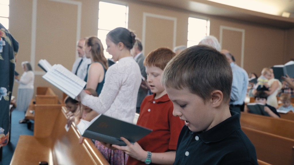 Children of the congregation singing from hymnals in the pews
